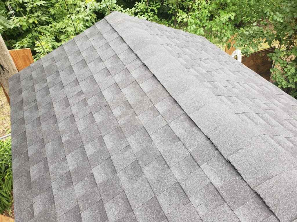 Asphalt roofing shingles installed on site on a custom storage shed.