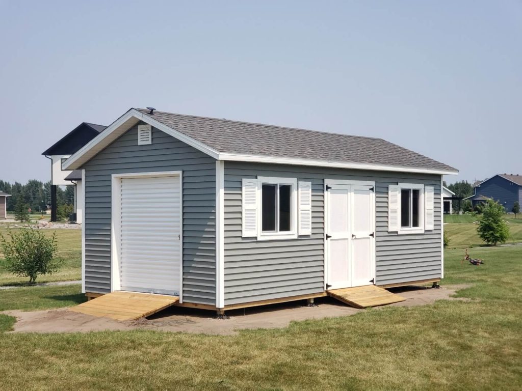 Fargo custom storage shed with vinyl siding and vented overhangs.